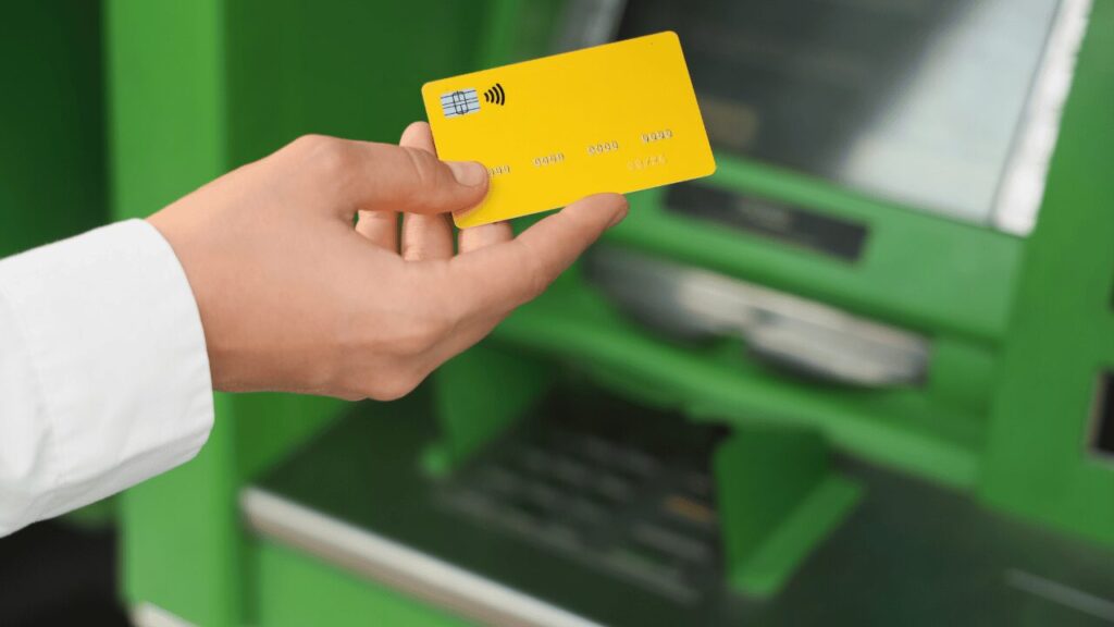 ATMの前でクレジットカードを出してる人